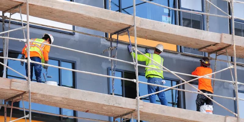 Contruction workers renovating the facade of a building