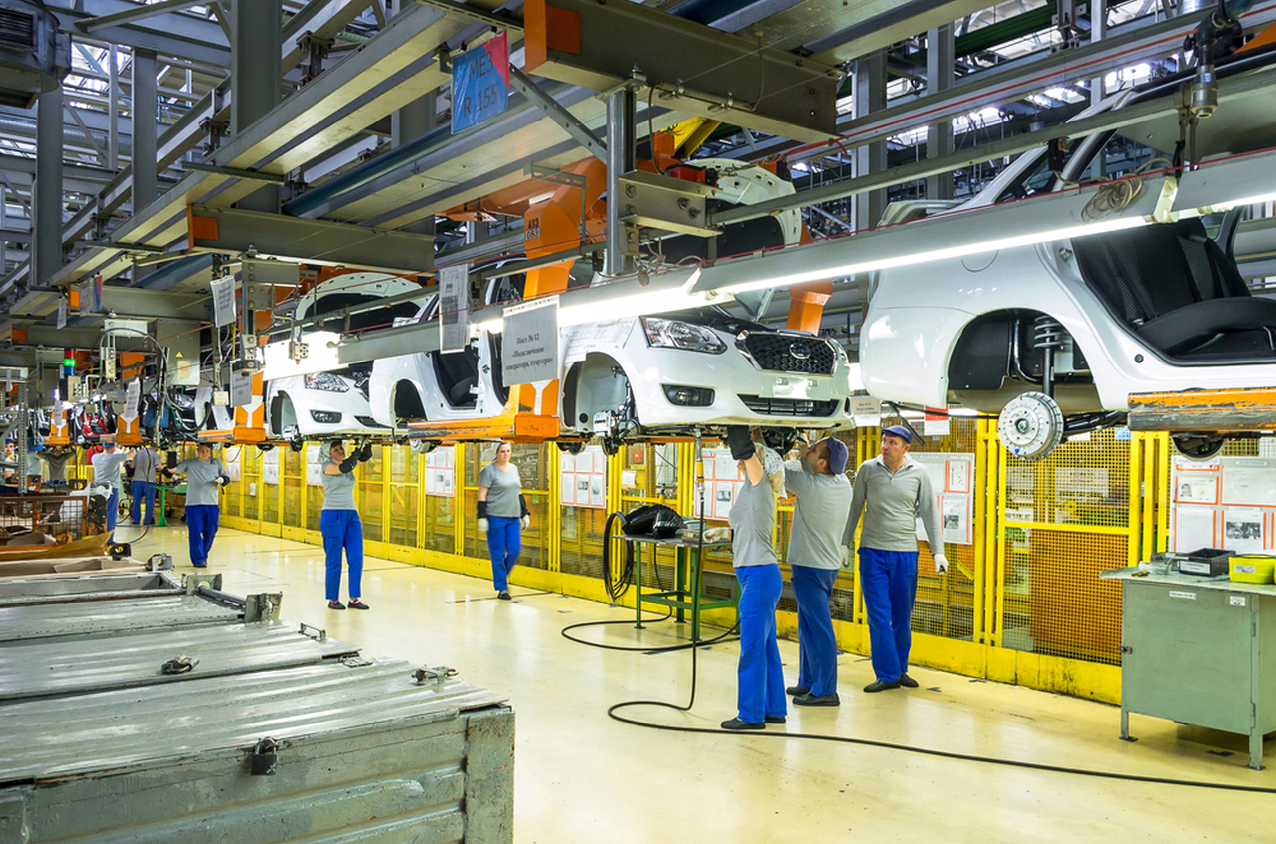 Factory workers working on car assembly line