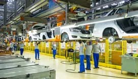 Factory workers working on car assembly line