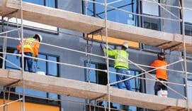 Contruction workers renovating the facade of a building