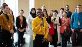 Smiling female speaker with microphone on stage