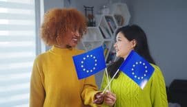 Multiracial friendship and equality, African american and asian woman holding european union flag.