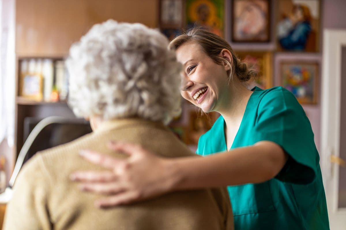 Friendly nurse supporting an elderly lady