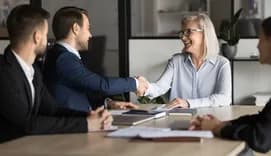 Woman and man shaking hands at business meeting