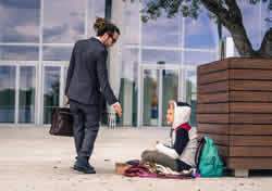 Image of businessman helping a homeless youth