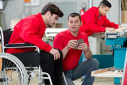 Image of disabled worker receiving instruction in carpenters' workshop