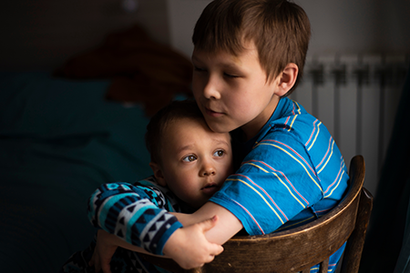 Portrait of two sad boys, sitting by the window © Ekaterina/Adobe Stock